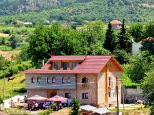 a building with a red roof on a hill at Bujtina Celiku in Burrel