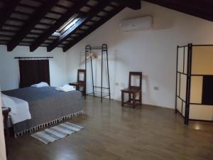 a room with a bed and two chairs in it at Al Rol in Manzano