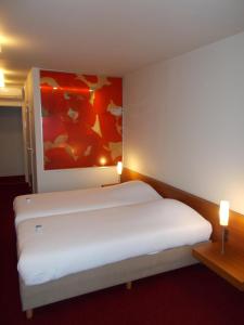 A bed or beds in a room at Hotel Corbie Lommel