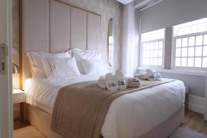a bedroom with a large white bed with towels on it at Torre Medieval in Viseu +73 photos