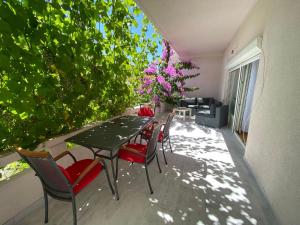 - une terrasse avec une table, des chaises et des fleurs dans l'établissement Apartment Nera Zadar, à Zadar