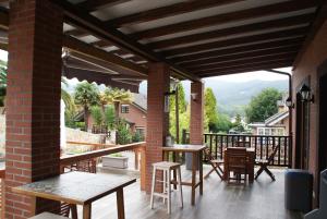 un patio con mesas y sillas en el balcón en El ParaÍso de Guriezo, en Pomar
