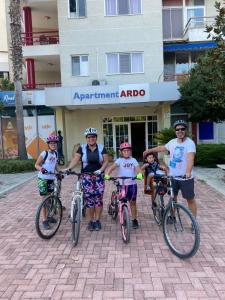 un grupo de personas en bicicleta delante de un edificio en HOTEL Apartments ARDO, en Golem