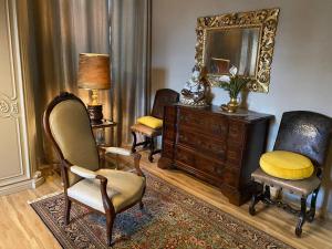 un soggiorno con sedie, cassettiera e specchio di Bice house a Terni