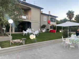 a patio with white tables and chairs and an umbrella at Bice house in Terni