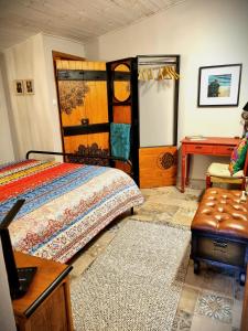 een slaapkamer met een bed, een bureau en een stoel bij Quinta do Cabril in Serpins