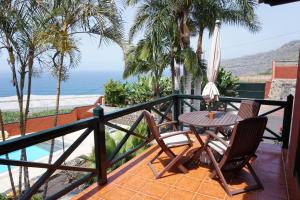 une terrasse avec une table et des chaises et l'océan dans l'établissement Finca La Romera, à La Orotava