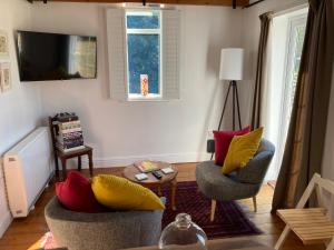 uma sala de estar com duas cadeiras e uma televisão em Hunters Moon B&B em North Tidworth