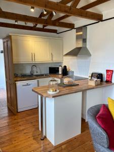 uma cozinha com armários brancos e um balcão de madeira em Hunters Moon B&B em North Tidworth