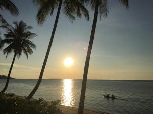 a group of people in a boat in the water with palm trees at Jasmine & Tea House in Mae Nam