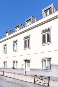 un bâtiment blanc avec un banc devant lui dans l'établissement Monsanto Hill House - NO. 565 1E, à Lisbonne