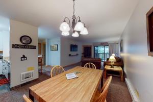 a dining room and living room with a wooden table and chairs at The Summit 206 in Old Mammoth