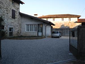 a driveway in front of a house with a car at Al Rol in Manzano