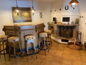 a kitchen with a bar with stools and a fireplace at Idyllisches Ferienhaus “Werra Ausblick” am Meißner in Hitzerode