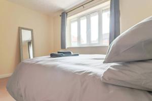 ein weißes Bett mit einem Fenster in einem Schlafzimmer in der Unterkunft Delightful 2 Bed Room Property, Free Off Road Parking. in Cleethorpes