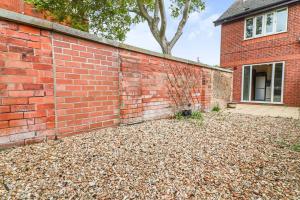 a brick wall next to a building with a tree at Delightful 2 Bed Room Property, Free Off Road Parking. in Cleethorpes