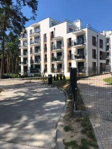 un grande condominio con una recinzione di fronte di Apartament Business & Living No 98 nad Zalewem w Cedzynie, Miejsce parkingowe a Cedzyna