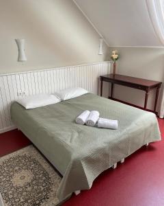 a bedroom with a bed with two towels on it at A. Smetonos Dvaro Smetonienės svetainė in Lėnas