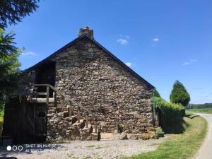 un ancien bâtiment en pierre avec un escalier en avant dans l'établissement Gîte Le Grenier Cottage anglais Morbihan, à Réminiac