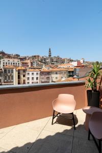 a chair on a balcony with a view of a city at Mouzinho Village River in Porto