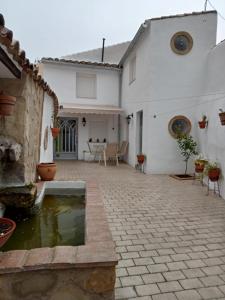 une maison blanche avec un étang dans la cour dans l'établissement ALOJAMIENTO RURAL EL CARRIL, à Pegalajar