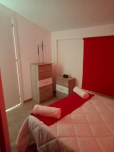 - une chambre avec un lit rouge et une commode dans l'établissement ALOJAMIENTO RURAL EL CARRIL, à Pegalajar
