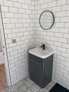 a white tiled bathroom with a sink and a mirror at River View Lodge in Felton +14 photos