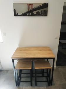 a wooden table and bench in front of a wall at Le New York de Marchaux 2 in Marchaux