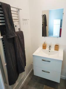 a bathroom with a white sink and a mirror at Le New York de Marchaux 2 in Marchaux