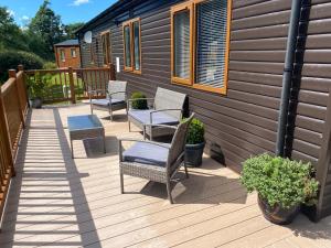 a deck with chairs and tables and a house at River View Lodge in Felton
