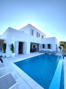 a villa with a swimming pool in front of a house at sun senses luxury Vilas Dione in Piso Livadi