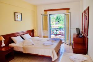 ein Schlafzimmer mit einem großen Bett und einem Balkon in der Unterkunft Venardos Hotel in Agia Pelagia, Insel Kythira