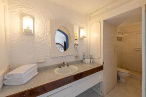 a bathroom with a sink and a toilet and a mirror at Hotel Maya Caribe Faranda Cancún in Cancún