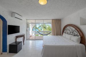 a bedroom with a bed and a tv and a window at Hotel Maya Caribe Faranda Cancún in Cancún