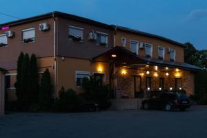 a building with a car parked in front of it at Hotel Tranzit in Odorheiu Secuiesc