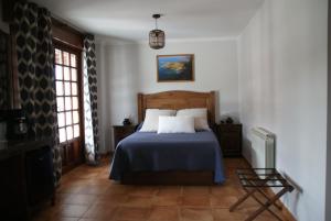 a bedroom with a bed with a blue blanket at El ParaÍso de Guriezo in Pomar
