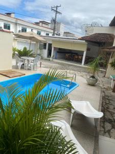 un patio con piscina, mesa y sillas en Pousada Rancho Verde, en Porto Seguro