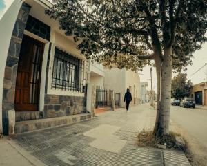 a person walking down a sidewalk next to a building at Raices Andinas in Tinogasta