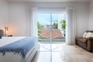 a bedroom with a bed and a view of a balcony at Ocean Front Condominium in Puerto Aventuras