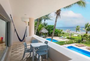 a balcony with a hammock and a view of the ocean at Ocean Front Condominium in Puerto Aventuras
