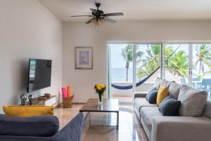 a living room with a couch and a flat screen tv at Ocean Front Condominium in Puerto Aventuras