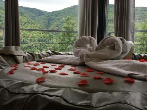 a bed with towels and roses on it with a window at Chambres d'hôtes Mas La Tardosse in Prats-de-Mollo-la-Preste