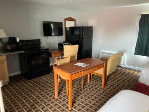 a hotel room with a table and chairs and a kitchen at Budget Inn in Tallahassee