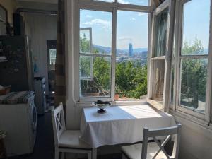 a table and two chairs in a room with a window at Дом Тины in Tbilisi City