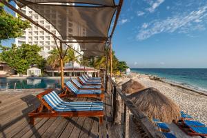a row of lounge chairs on a beach at Hotel Maya Caribe Faranda Cancún in Cancún