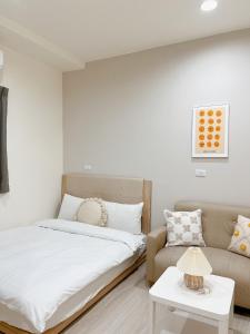 台南的住宿－和和窩台南民宿，一间卧室配有一张床和一张沙发