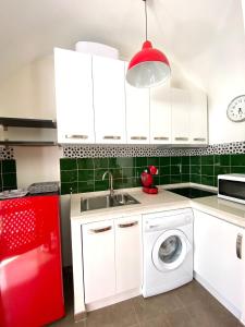 eine Küche mit einer Waschmaschine und einem roten Kühlschrank in der Unterkunft La bodeguita 1 in Zafra