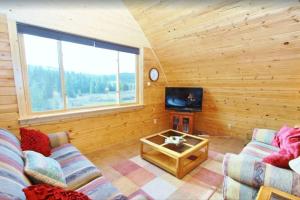 een woonkamer met een bank en een tv bij Red Cedar in West Yellowstone