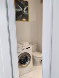 a bathroom with a washing machine and a toilet at Ann's Apartment in Białystok