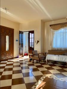 uma sala de estar com piso em xadrez e um quarto em Doctor's House em Guiumri